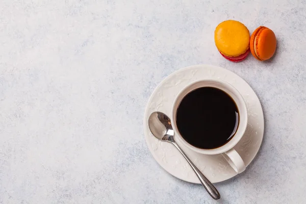 Weiße Tasse mit Kaffee, Makkaroni auf grauem horizontalen Hintergrund — Stockfoto