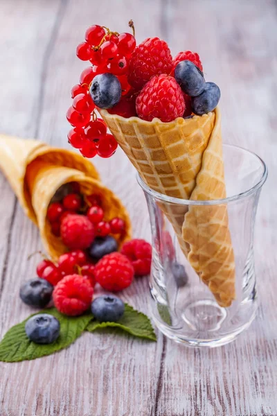 Cone de waffle de açúcar com bagas florestais verticalmente — Fotografia de Stock