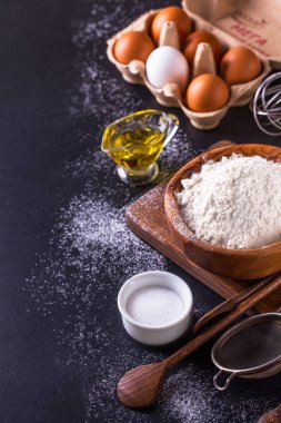 Ekmek karanlık bir arka plan üzerinde dikey olarak yemek pişirmek için malzemeler