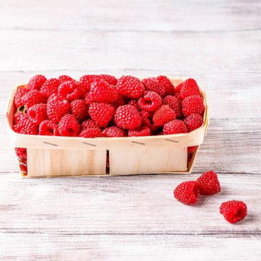 hafif ahşap arka plan üzerinde bir hasır sepet içinde ahududu