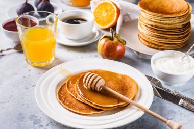 Bal, meyve ve gri arka plan üzerinde kahve ile Pancakes