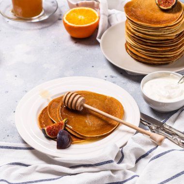 Bal, meyve ve gri arka plan üzerinde kahve ile Pancakes