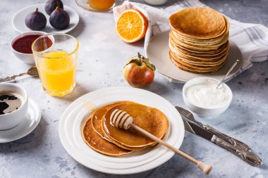 Bal, meyve ve gri arka plan üzerinde kahve ile Pancakes