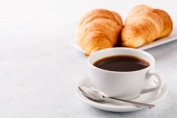 Breakfast of oatmeal with berries, coffee with croissants on a blue background, horizontally — Stock Photo, Image