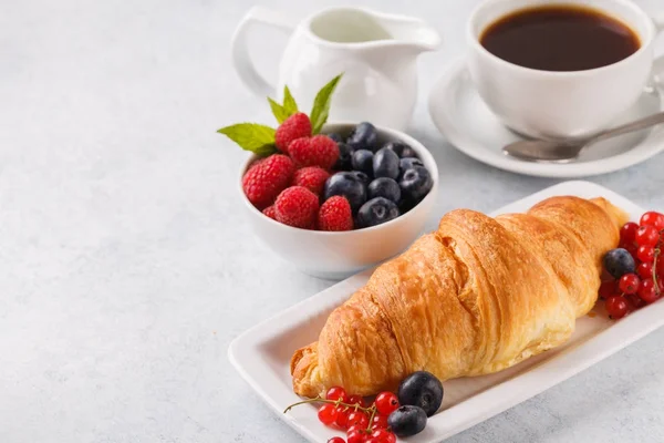 Colazione di farina d'avena con frutti di bosco, caffè con croissant su sfondo blu, orizzontalmente — Foto Stock