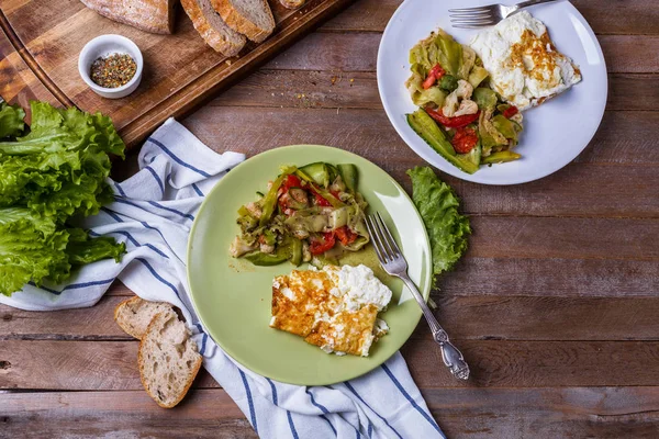 Tortilla con ensalada de verduras en platos de colores sobre un fondo de madera —  Fotos de Stock