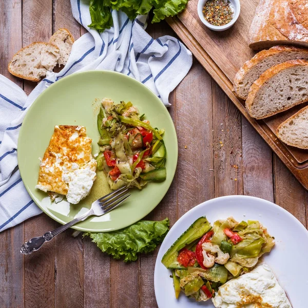 Tortilla con ensalada de verduras en platos de colores sobre un fondo de madera —  Fotos de Stock