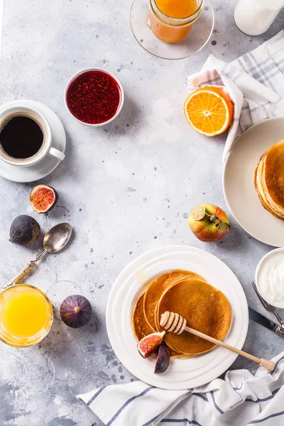 Bal, meyve ve gri arka plan üzerinde kahve ile Pancakes