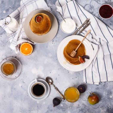 Bal, meyve ve gri arka plan üzerinde kahve ile Pancakes