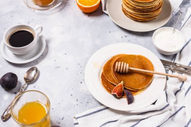 Bal, meyve ve gri arka plan üzerinde kahve ile Pancakes