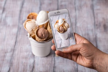 Creme brulee, çikolata, vanilyalı dondurma waffle içinde boynuz hafif bir arka plan üzerinde dikey olarak