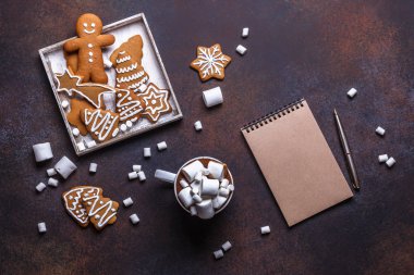 Sıcak çikolata ve marshmelow, karanlık bir arka plan eller üzerinde beyaz ahşap kutu içinde Noel kurabiyeleri