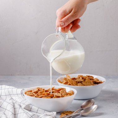 gri bir arka plan üzerine sütlü beyaz tabak kuru odaya bir şerit, kare, bir havlu ile eller