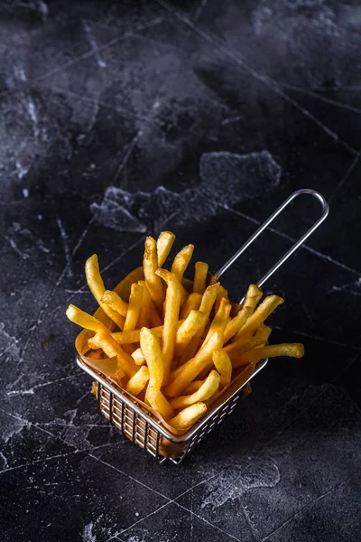 Papas fritas en una canasta sobre fondo negro —  Fotos de Stock