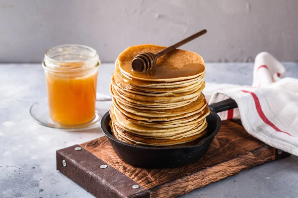 Panqueques con miel sobre fondo gris — Foto de Stock