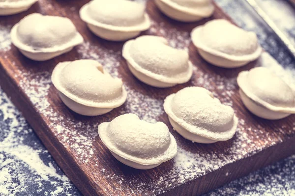 Rohe Knödel auf schwarzem Hintergrund, Mehl, Nudelholz, Löffel, waagerecht, flach — Stockfoto