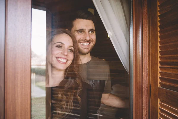 Man and young woman look at window.
