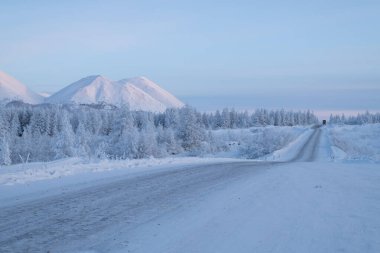 Ust-Nera, Oymyakonsky Bölgesi / Sakha Cumhuriyeti, Rusya-Ocak 04-2020: Karlı dağ yolu olan kış manzarası alacakaranlıkta. Yakutian karayolu Kolyma, Kemiklerin üzerindeki yol olarak da bilinir.