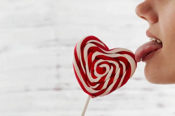 De dag van Valentijnskaarten, tong likken snoep in de vorm van een hart, ruimte voor tekst — Stockfoto