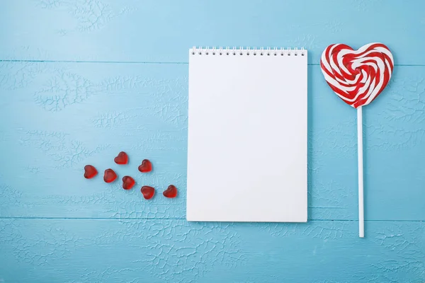 Metin, lolipop, kalp için boş not defteri. Mavi masa