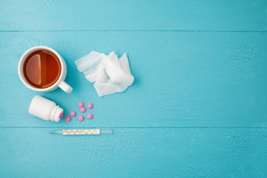 termometre, tablet, nane peçete ve mavi bir arka plan üzerinde çay