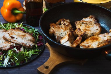 kızarmış et bir tavada salata, otlar, koyu ahşap arka plan üzerinde biber. Kartpostal için arka plan.