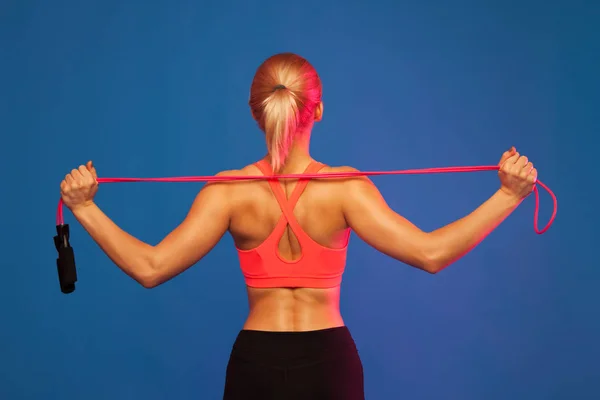 mavi bir arka plan üzerinde bir jumper ile poz sportif sarışın kız