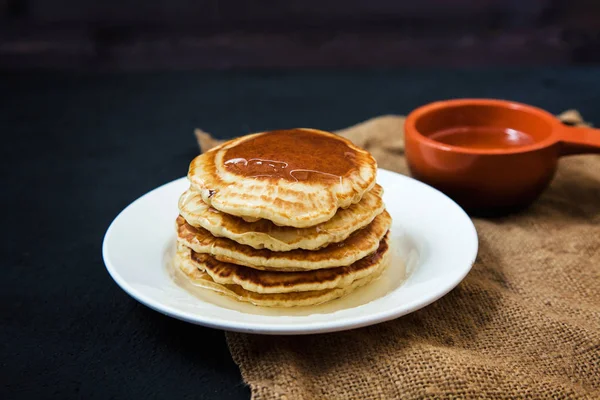 Appetitliche Pfannkuchen mit Honig auf einem dunklen Tisch. Menü, Restaurant Rezeptkonzept. serviert in. — Stockfoto