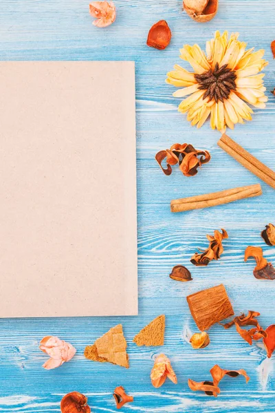 Herfst droge gele en rode bloemen op een blauwe houten achtergrond en notepad textuur, achtergrond Concept voor een briefkaart plaats voor tekst — Stockfoto