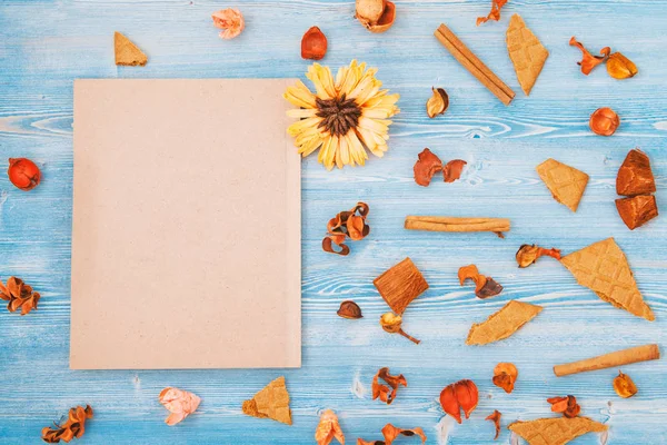 Gele en rode bloemen op een blauwe houten achtergrond en notepad textuur, achtergrond Concept voor een briefkaart plaats voor tekst — Stockfoto