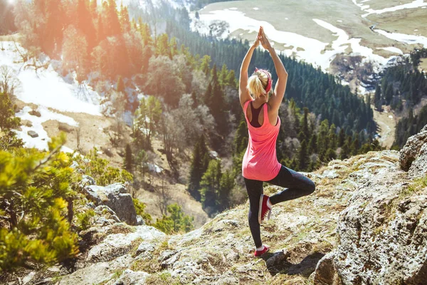 genç kız gezgin bir yoga poz bir dağın tepesinde oturuyor. Kız seyahat etmeyi seviyor. Kavramı için seyahat etmek. Arka arka plan Dağı'nda turist Gezgin görüntülemek