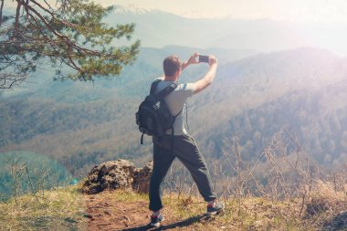arka arka plan Dağı'nda turist Gezgin smartphone görünümünden dağ ve alır resimlerini üzerine dikilen adam seyahat.