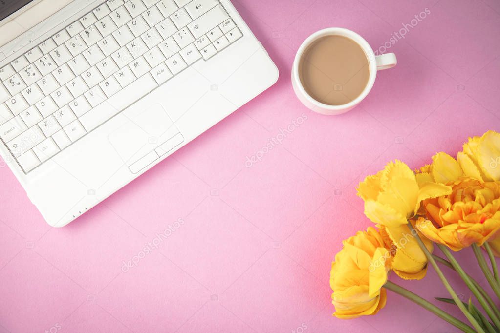 yellow tulips, laptop and coffee on a lilac background Spring, summer concept Flat lay Top view