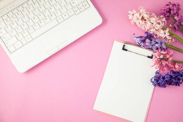 lilac flowers, laptop and notepad on a lilac background Spring, summer concept Flat lay Top view Copyspace