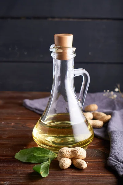 Healthy Peanut oil in glass bottles. Dark wooden background Copy space