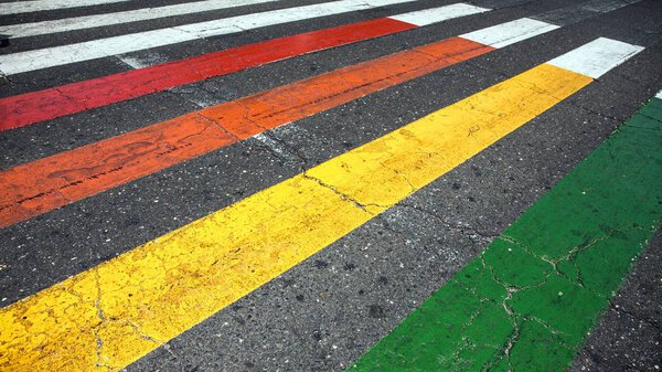 Multi colored cross walk background on the asphalt surface