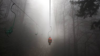 People on the Mountain lift in foggy weather  clipart