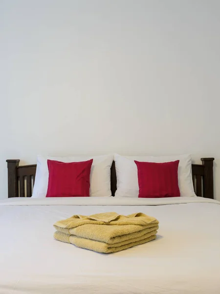 White bedroom with tidy white bed and yellow towels — Stock Photo, Image