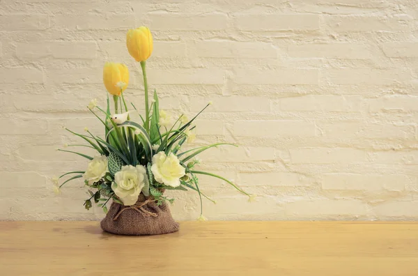 Fleurs artificielles décorées sur table en bois — Photo