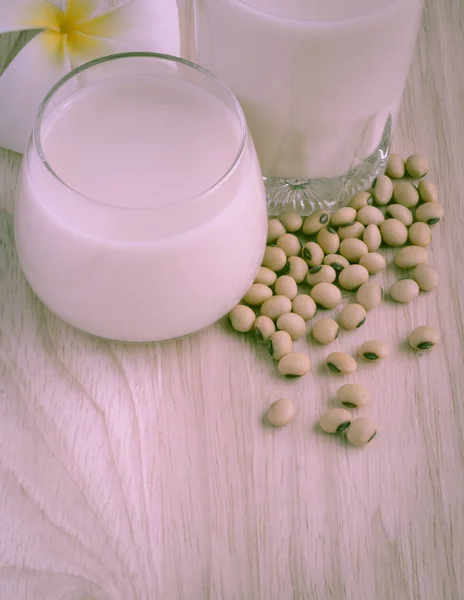 Latte di soia fresco (latte di soia) in un bicchiere e semi di soia — Foto Stock