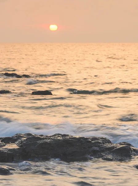 Sea sunrise with rock on beach — Stock Photo, Image