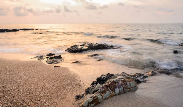 Zee zonsopgang met rotsen aan strand — Stockfoto