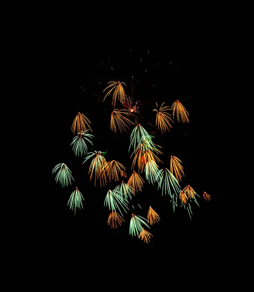 Belos fogos de artifício verdes e amarelos explodindo no céu noturno , — Fotografia de Stock