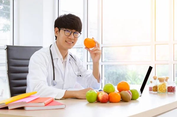 Manlig Dietist Vit Labbrock Som Håller Apelsinfrukt Klinikrummet Med Färska — Stockfoto