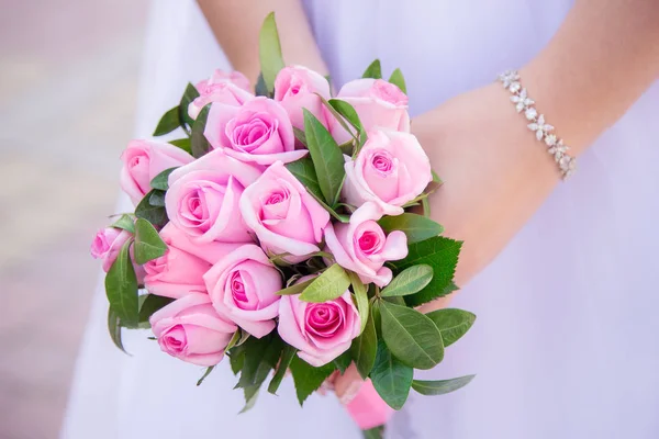 Růžové růže kytice v rukou nevěsty — Stock fotografie