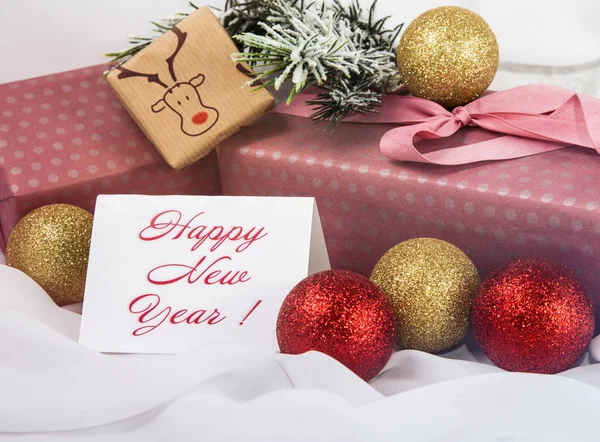 Christmas sign, Christmas tree in the snow, Christmas gold ornaments and Packed gifts