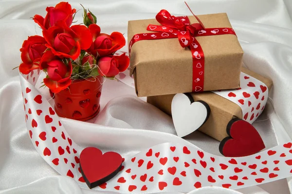 red and white otkrtyka with hearts, a bucket of roses, a gift and ribbons for Valentine\'s Day