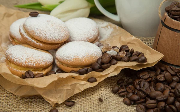 bir fincan kahve süt, bisküvi, kaba bir arka plan üzerinde Beyaz Lale bir buket ile gelen bahar natürmort