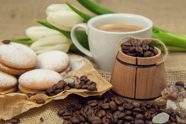 bir fincan kahve süt, bisküvi, kaba bir arka plan üzerinde Beyaz Lale bir buket ile gelen bahar natürmort