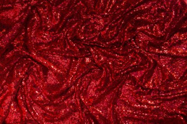 Parlak kırmızı pliat kumaş zemin olarak kaplanmış.
